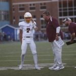 Zach Kostopoulos of Highlands gets the playcall from his coaches during the football game between Cooper and Highlands on Friday, Aug. 28, 2026, at Highlands High School.