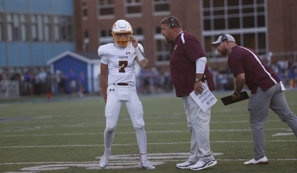 Zach Kostopoulos of Highlands gets the playcall from his coaches during the football game between Cooper and Highlands on Friday, Aug. 28, 2026, at Highlands High School.